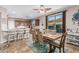 A bright dining area features a table for six, a ceiling fan, and is adjacent to the kitchen with counter seating at 16077 W Anasazi St, Goodyear, AZ 85338