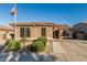 Charming single-story home featuring a tiled roof, landscaped front yard, and an American flag on a pole at 16077 W Anasazi St, Goodyear, AZ 85338