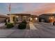 Charming single-story home featuring a tiled roof, landscaped front yard, and an American flag on a pole at 16077 W Anasazi St, Goodyear, AZ 85338