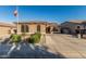 Charming single-story home featuring a tiled roof, landscaped front yard, and an American flag on a pole at 16077 W Anasazi St, Goodyear, AZ 85338