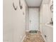 Bright hallway with neutral tones, tile flooring, and decorative wall art leading to the front door at 16077 W Anasazi St, Goodyear, AZ 85338