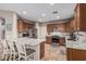 A spacious kitchen boasts granite countertops, a breakfast bar, stainless steel appliances, and wooden cabinetry at 16077 W Anasazi St, Goodyear, AZ 85338