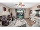 A comfy living room features a ceiling fan, tile floors, and access to a patio through sliding glass doors at 16077 W Anasazi St, Goodyear, AZ 85338