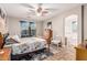 A serene main bedroom features a ceiling fan, nautical decor, and an arched doorway to the ensuite bath at 16077 W Anasazi St, Goodyear, AZ 85338