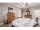 A bright main bedroom features a ceiling fan, wood furnishings, and a cheerful atmosphere for rest and relaxation at 16077 W Anasazi St, Goodyear, AZ 85338