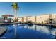 Backyard oasis with sparkling pool, rock waterfall feature, and patio seating under a shady palm tree at 16077 W Anasazi St, Goodyear, AZ 85338