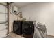 Modern laundry room setup with large-capacity front load washer and dryer and storage at 1676 W Sequoia Dr, Phoenix, AZ 85027