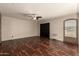 Spacious living room featuring dark wood flooring, fan and arched entryway at 1676 W Sequoia Dr, Phoenix, AZ 85027