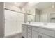 Modern bathroom with double vanity, framed mirrors, and a glass-enclosed shower at 17032 W Cavedale Dr, Surprise, AZ 85387