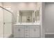 Modern bathroom with double vanity, large mirrors, and a glass-enclosed shower at 17032 W Cavedale Dr, Surprise, AZ 85387