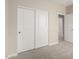 Neutral carpeted bedroom features bright-white trim, walls, and a sliding-door closet at 17032 W Cavedale Dr, Surprise, AZ 85387