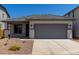 Charming single-story home with gray trim, a gray garage door, and desert landscaping at 17032 W Cavedale Dr, Surprise, AZ 85387