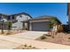 Charming single-story home with gray trim, a gray garage door, and desert landscaping at 17032 W Cavedale Dr, Surprise, AZ 85387