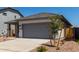 Charming single-story home with gray trim, a gray garage door, and desert landscaping at 17032 W Cavedale Dr, Surprise, AZ 85387