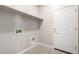 Bright laundry room with storage shelf and easy access to hookups and the backyard at 17032 W Cavedale Dr, Surprise, AZ 85387