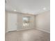 Well-lit living room with large window overlooking the front yard and neutral-colored flooring at 17032 W Cavedale Dr, Surprise, AZ 85387