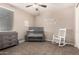 Charming Bedroom features neutral colors, a gray crib, dresser, and white rocking chair at 18334 W Marshall Ln, Surprise, AZ 85388