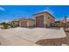 View of the side of the house, showcasing the three-car garage and extended driveway for extra parking space at 18334 W Marshall Ln, Surprise, AZ 85388