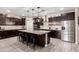 Modern kitchen with a large center island, dark wood cabinetry, and stainless steel appliances at 18334 W Marshall Ln, Surprise, AZ 85388