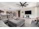 Open-concept living room featuring a modern ceiling fan, shiplap wall, and access to the kitchen and dining area at 18334 W Marshall Ln, Surprise, AZ 85388