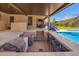 Covered patio features a full outdoor bar, seating, and clear view of the sparkling pool at 18334 W Marshall Ln, Surprise, AZ 85388