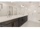 Bright bathroom featuring a double vanity with dark wood cabinets and a glass-enclosed shower at 2121 W Sonoran Desert Dr # 14, Phoenix, AZ 85085