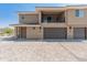 Modern two-story home featuring a balcony, gray garage doors, and a neutral color scheme against a clear blue sky at 2121 W Sonoran Desert Dr # 14, Phoenix, AZ 85085