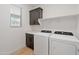 Laundry room featuring modern appliances and dark wood cabinets with shelving at 2121 W Sonoran Desert Dr # 14, Phoenix, AZ 85085