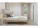 Well-lit bedroom featuring a simple bed frame, neutral decor, and a view from the window at 24971 N 167Th Dr, Surprise, AZ 85387