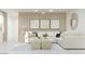 Cozy living area showcasing a white sectional sofa, natural light, and modern artwork at 24971 N 167Th Dr, Surprise, AZ 85387