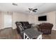 Cozy living room featuring wood-look floors, a ceiling fan, and comfortable leather seating at 2516 E San Manuel Rd, San Tan Valley, AZ 85143