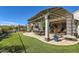Backyard patio with multiple seating areas and well-manicured lawn, perfect for relaxation and entertainment at 25979 W Taro Dr, Buckeye, AZ 85396