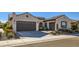 Charming home exterior featuring a two-car garage, desert landscaping, and a stucco facade with a tile roof at 25979 W Taro Dr, Buckeye, AZ 85396