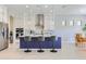 Modern kitchen features an island with barstool seating and pendant lighting, stainless steel appliances, and tile floors at 25979 W Taro Dr, Buckeye, AZ 85396