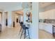 Kitchen bar features a white countertop with black chairs, hanging pendant lights, and tile floors at 25979 W Taro Dr, Buckeye, AZ 85396