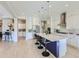 Bright kitchen featuring a large island with bar seating, white cabinets, stainless steel appliances and tile floors at 25979 W Taro Dr, Buckeye, AZ 85396