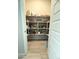 Walk-in pantry with shelving, storing food, drinks, and small appliances, through an open doorway at 25979 W Taro Dr, Buckeye, AZ 85396