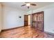 Bedroom featuring hardwood floors, ceiling fan, closet, and door to another room at 2602 S 226Th Dr, Buckeye, AZ 85326