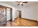 Bedroom featuring hardwood floors, a ceiling fan, closet, and door to another room at 2602 S 226Th Dr, Buckeye, AZ 85326