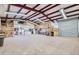 Spacious garage with high ceilings, metal beams, storage, and roll-up door at 2602 S 226Th Dr, Buckeye, AZ 85326
