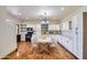 Spacious kitchen featuring white cabinets, modern appliances, and a wooden dining table at 2602 S 226Th Dr, Buckeye, AZ 85326