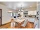 Bright kitchen with white cabinets, granite countertops, and light wood dining table at 2602 S 226Th Dr, Buckeye, AZ 85326
