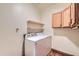 Laundry room featuring a white washer and dryer, overhead shelves, and oak cabinets at 2602 S 226Th Dr, Buckeye, AZ 85326