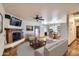 Inviting living room with a fireplace, ceiling fan, and access to the dining room and kitchen at 2602 S 226Th Dr, Buckeye, AZ 85326
