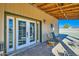 Outdoor patio featuring stone tile, french doors, and serene seating at 2602 S 226Th Dr, Buckeye, AZ 85326