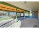 Inviting covered patio with brick flooring, mature flowers, and outdoor living space at 2602 S 226Th Dr, Buckeye, AZ 85326