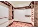 Custom-built walk-in closet featuring wood shelving, drawers, and hardwood floors at 2602 S 226Th Dr, Buckeye, AZ 85326