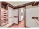 Custom-built walk-in closet featuring hardwood floors and a peek into the bathroom at 2602 S 226Th Dr, Buckeye, AZ 85326