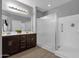 Bright bathroom featuring a double sink vanity, wood floors, and a walk-in shower at 2670 E Bellerive Dr, Gilbert, AZ 85298