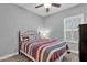 Cozy bedroom with a ceiling fan, a bed with striped bedding, and a shuttered window at 2670 E Bellerive Dr, Gilbert, AZ 85298